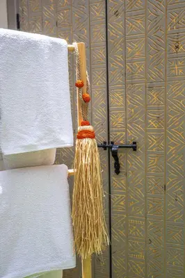 a towel rack with white towels and a broom at Riad Symba Exclusive with New Heated Pool and Breakfast Included in Marrakech