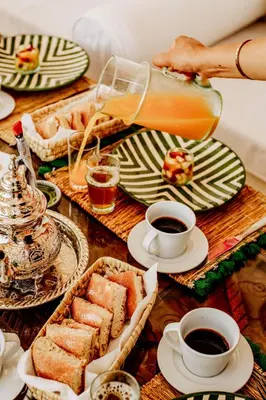a table topped with plates of food and cups of coffee at Dar Inara in Marrakech