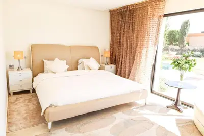 a bedroom with a bed and a large window at Villa Angel 42 Al Maaden Golf Resort in Marrakech