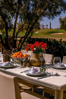 a table with a bowl of fruit and flowers on it at Villa Angel 42 Al Maaden Golf Resort in Marrakech