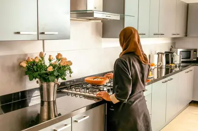 a woman standing in a kitchen preparing food at Villa Angel 42 Al Maaden Golf Resort in Marrakech