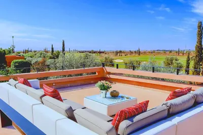 a patio with a white couch and red pillows at Villa Angel 42 Al Maaden Golf Resort in Marrakech