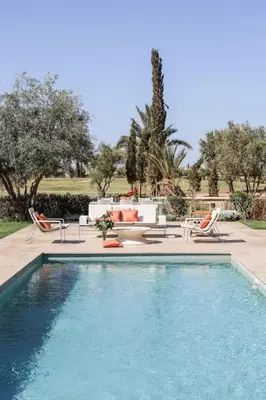 a swimming pool in a yard with chairs and a table at Villa Angel 42 Al Maaden Golf Resort in Marrakech