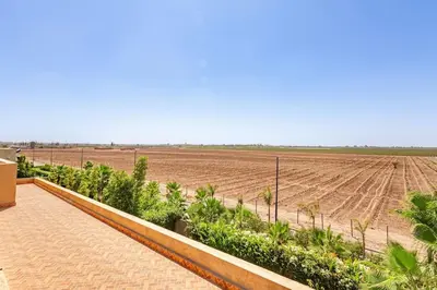 a farm with a dirt field in the background at Villa Narjisse , Élégance et Calme, piscine privée in Marrakech