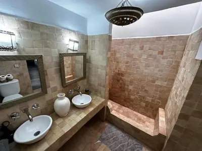 a bathroom with two sinks and a tub and a mirror at Dar Hatim in Marrakech