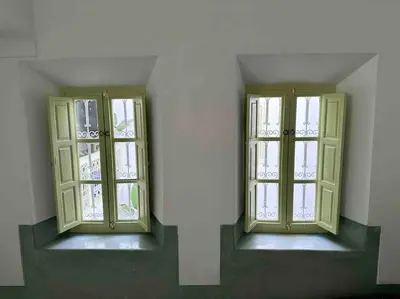 two windows in a room with green walls at Dar Hatim in Marrakech