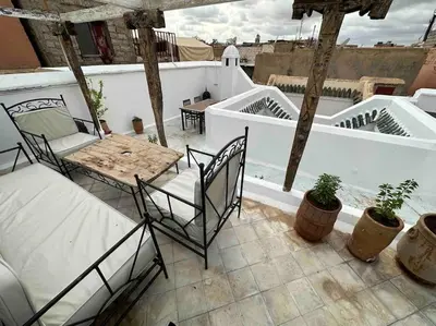a patio with a table and chairs on a balcony at Dar Hatim in Marrakech