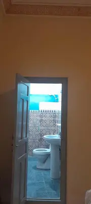 a bathroom with a toilet and a sink through a door at Riad Ramadan House Marrakech in Marrakech