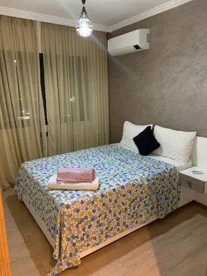 a bedroom with a bed with a blue and white blanket at Nour5 in Marrakech