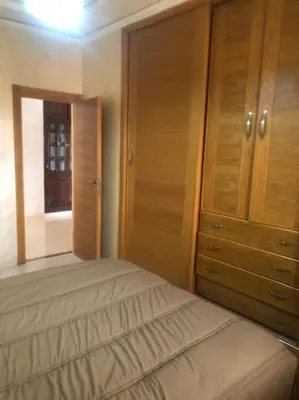 a bedroom with a bed and a wooden cabinet at Marrakech-Central location 2 Bdrm in Marrakech