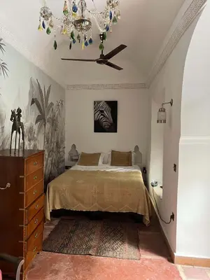 a bedroom with a bed and a chandelier at Riad Panthera, Médina in Marrakech