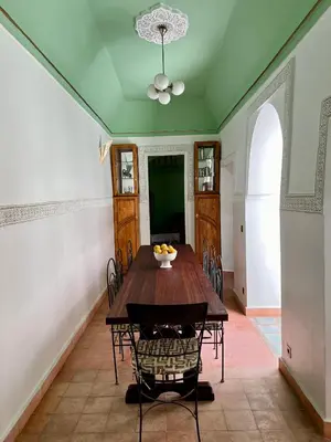 a dining room with a wooden table and chairs at Riad Panthera, Médina in Marrakech