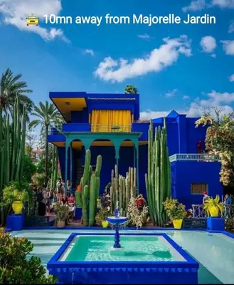 a blue building with a fountain in front of a cactus at appartement 9 simple et fonctionnel pour famille in Marrakech