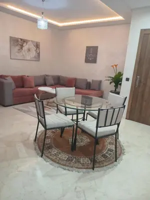 a living room with a glass table and chairs at Luxury Apartment With Swiming Pool in Hivernage Marrakech in Marrakech