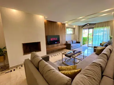 a large living room with a couch and a tv at Prestigia Apart 29 in Marrakech