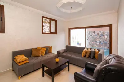 a living room with two couches and a table at Beautiful Central Marrakech Villa in Marrakech