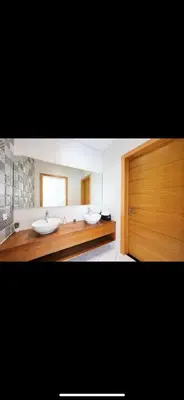 a bathroom with two sinks and a wooden door at Beautiful villa Argan golf in El Makina