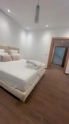 a bedroom with a white bed and a wooden floor at Beautiful villa Argan golf in El Makina