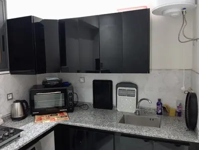 a kitchen with black cabinets and a sink and a microwave at Marrakech -giliz in Marrakech