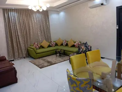 a living room with a green couch and yellow chairs at Marrakech -giliz in Marrakech