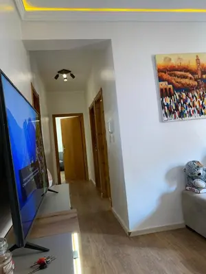 a living room with a flat screen tv and a couch at Cosy & chill home in Marrakech