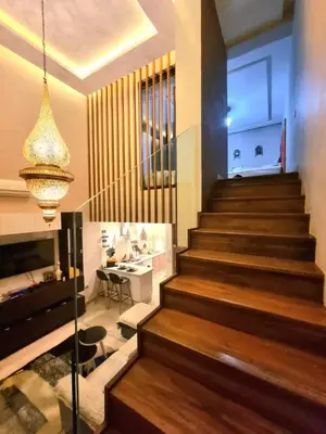 a staircase in a house with a table and a chandelier at Nid douillet dans la ville Rose in Marrakech