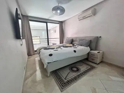 a bedroom with a bed in a room with a window at Appartement Duplex Haut Standing in Marrakech