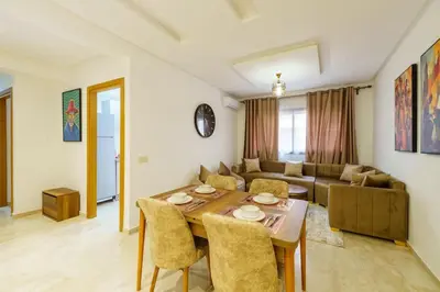 a living room with a table and a couch at Luxury Appartement Cosy 2BR City center Secure Parking Wifi in Marrakech