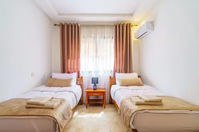 two beds in a room with a window at Luxury Appartement Cosy 2BR City center Secure Parking Wifi in Marrakech