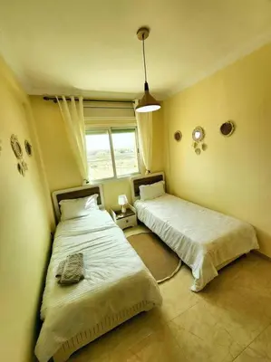 two beds in a room with a window at Residence Blida Gueliz 2 Chambres in Marrakech