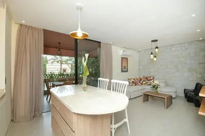 a kitchen and living room with a table and a couch at Appartement luxe type Suite hôtel Hivernage in Marrakech