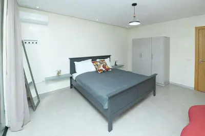 a bedroom with a bed in a white room at Appartement luxe type Suite hôtel Hivernage in Marrakech