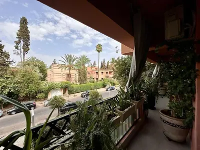 a balcony with plants and a view of a street at Appartement luxe type Suite hôtel Hivernage in Marrakech