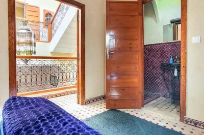 a bedroom with a door and a staircase at Al Qaria Assiyahia Riad Fadil 44 in Marrakech