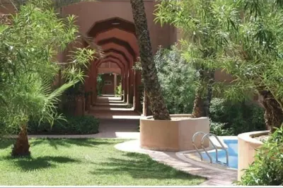 a hallway with palm trees in a building at Al Qaria Assiyahia Riad Fadil 44 in Marrakech
