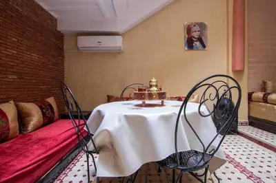 a room with a table and chairs and a couch at Al Qaria Assiyahia Riad Fadil 44 in Marrakech