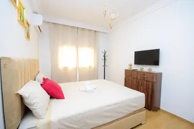 a small bedroom with a bed and a television at Cosy flat - gueliz residency in Marrakech