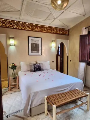 a bedroom with a large bed with flowers on it at Riad Mumtaz Marrakech in Marrakech
