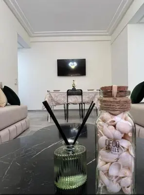 a living room with a glass jar of shells on a table at Proche Gueliz T3 Piscine Parking Wifi in Marrakech
