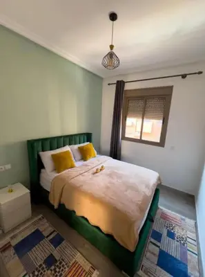 a bedroom with a large bed with yellow pillows at Proche Gueliz T3 Piscine Parking Wifi in Marrakech