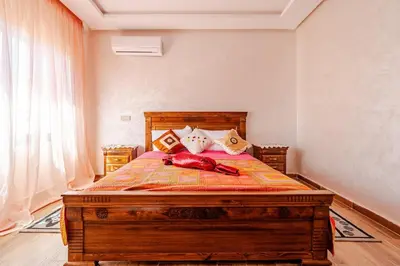 a bedroom with a large wooden bed with pillows at Duplex romantique Esprit palais à Gueliz in Marrakech