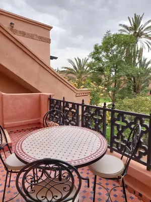 a patio with a table and chairs on a balcony at Atlas Golf resort in Sfiani