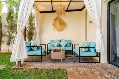 a patio with blue couches and a table at Villa michlo in El Makina