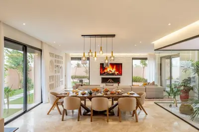 a dining room with a table and a fireplace at Villa Piscine, Salle de Sport et Confort Moderne in Marrakech