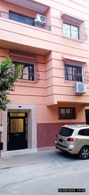 a pink building with a car parked in front of it at Nassim 298 in Marrakech