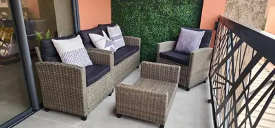three wicker chairs with pillows on a balcony at Luxury Condo in Downtown Hivernage Neighborhood in Marrakech