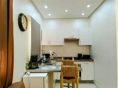 a small kitchen with white cabinets and a sink at Cozy studio in Marrakech district in Marrakech