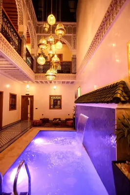 a large indoor pool in a building with purple lighting at Riad Palais MERYEM in Marrakech