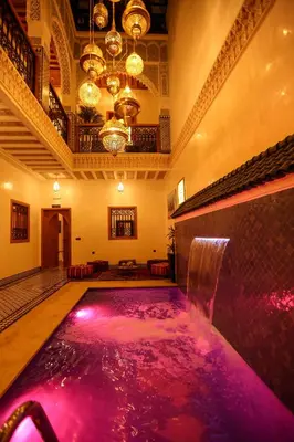 a swimming pool with pink water in a room at Riad Palais MERYEM in Marrakech