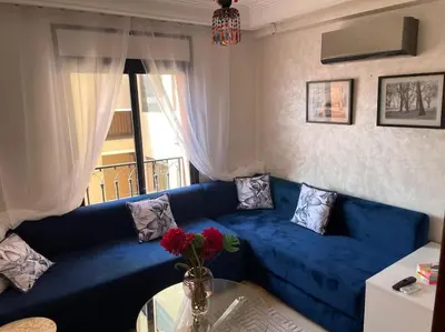 a blue couch in a living room with a window at Stylish & Comfy Gem 5 Star Location Balcony in Marrakech